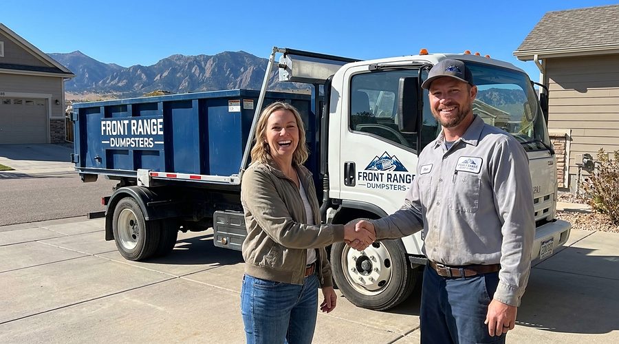 A homeowner shaking hands with a Front Range Dumpsters driver beside his truck